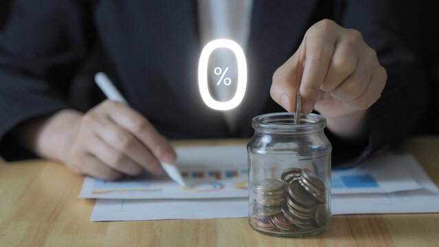 Zero tax or interest free savings concept with hand putting coin into glass jar. Financial planning, cost reduction, tax exemption, debt free strategy, and smart money management for individuals.