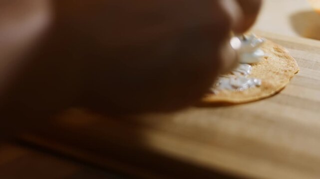 Spreading Philadelphia cream cheese on a yellow hin pancake