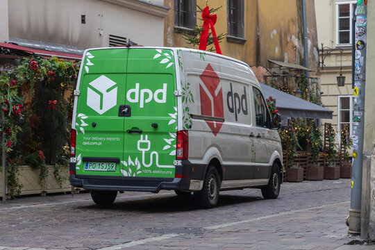 Krakow, Poland - December 2, 2025: DPD electric delivery van parked on a charming cobblestone street, adorned with festive holiday season decorations