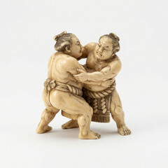 Obraz premium An antique Japanese netsuke figurine of two sumo wrestlers fighting. A traditional, hand-carved miniature sculpture isolated on a white background.