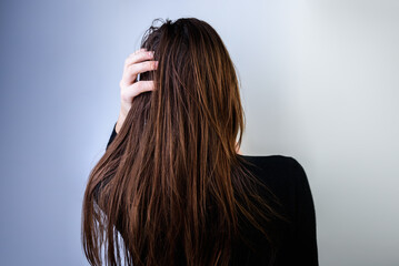 Fototapeta premium Young woman with dirty greasy hair on gray background.