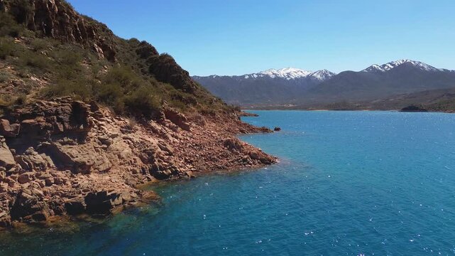 Aerial fly by of the rocky shores of lake Potrerillos in Mendoza, Argentina.