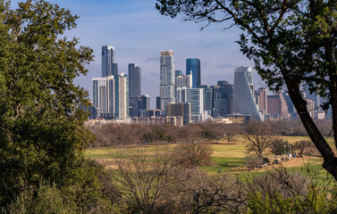 Obraz premium Framed view of Austin Texas city skyline through the trees of Zilker Botanic Gardens and park outside the city