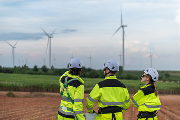 Engineers working on site in wind turbine farm, Wind turbines generate clean energy source, Eco...