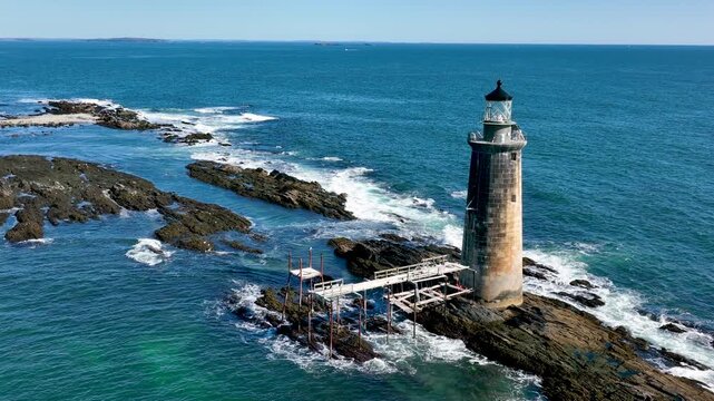 Aerial view of Ram Island Ledge Light contrasts against the turquoise sea and rocky outcrops, a beacon of maritime history, Portland, Maine, United States.