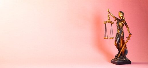 Statue of justice and scales of justice on a pink background.