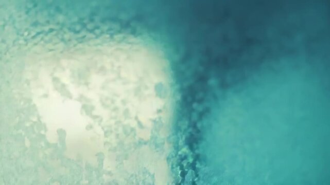 Frozen window glass etched with delicate ice crystals and ornate frost patterns, an abstract blue aqua winter texture glowing with soft light for seasonal backgrounds and wallpapers