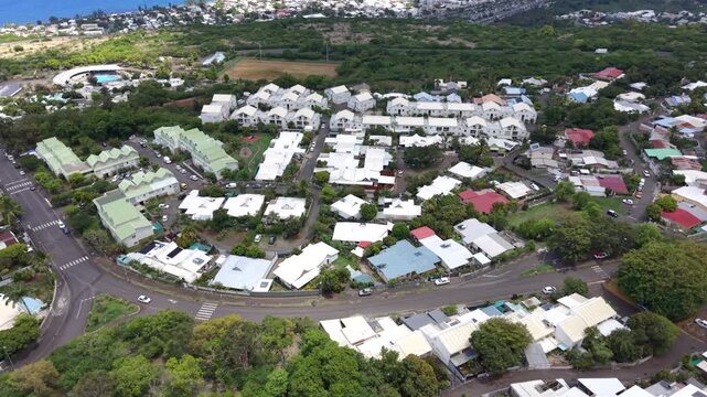 Drone tilt reveal from Plateau Cailloux in reunion island toward St Paul city and Indian Ocean coastline, Reunion Island