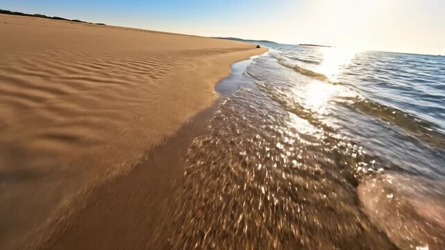 Sweeping low aerial drone view moving along a vast expanse of textured brown sand and shallow aqua blue water past a solitary conch shell remote, freedom, discovery