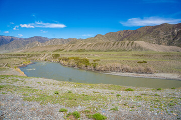 Katun River surrounded by mountains in Chuysky Trakt Altai Russia. Scenic Siberian river flowing through rugged mountain landscape.