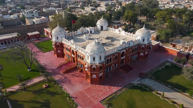 Aerial view of Barbar mahal bahawalpur with red brickwork contrasting against the lush green lawns and surrounding urban landscape, Bahawalpur, Punjab, Pakistan.