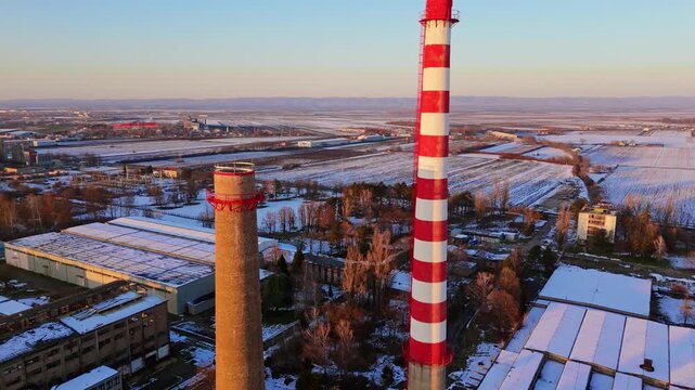 Aerial view of a red and white chimney stands tall, contrasting with the snowy landscape and buildings, Sremska Mitrovica, Vojvodina, Serbia.
