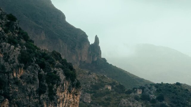 rocky outcrop sticks out of the fog