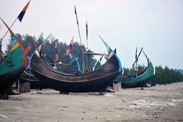 Obraz premium Moon Boat at Cox’s Bazar Beach, Bangladesh. A traditional moon-shaped fishing boat resting along the shoreline of Cox’s Bazar, Bangladesh.