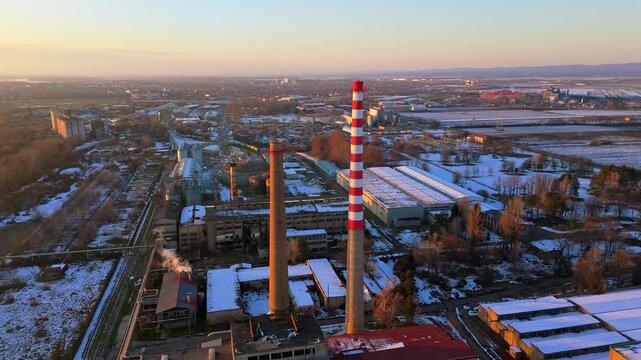 Aerial view of industrial landscape featuring chimneys, buildings, and snowy patches under a soft sky, Sremska Mitrovica, Vojvodina, Serbia.