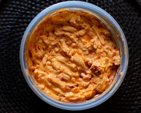 Pimento cheese in a plastic bowl from directly above. 