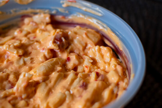 Pimento cheese up close in a plastic container.