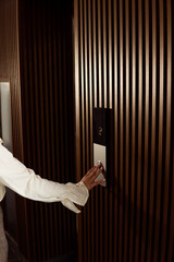 Woman pressing elevator button in modern building © Djavan Rodriguez