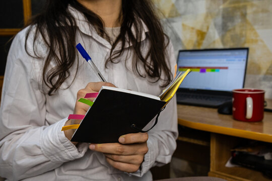 Woman writing in a planner at her home office desk