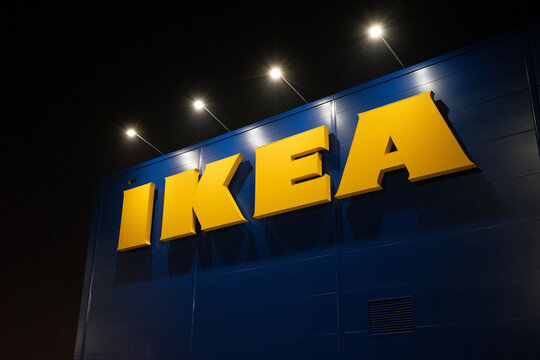 WARSAW, MASOVIAN, POLAND - JANUARY 20 2026: The iconic yellow IKEA logo mounted on a signature blue corrugated metal wall of a retail warehouse at night