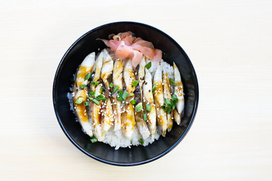 Pickled mackerel or Shime Saba donburi rice bowl with fresh slices, pickled ginger, and green onions. Traditional Japanese seafood meal, top view.