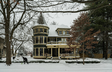 A man shovels the sidewalk in front of a Woodruff Place mansion Jan. 25, 2026. © Ted