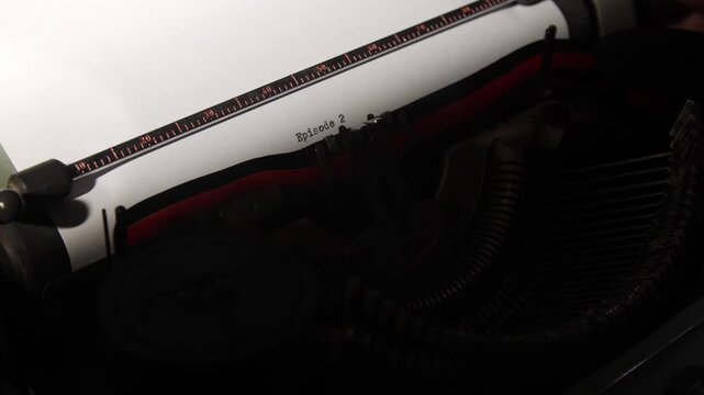 Vintage manual typewriter creating text on white paper, showing the beginning of a story or series with episode 2 typed on the page, representing creativity, narration, and sequential content