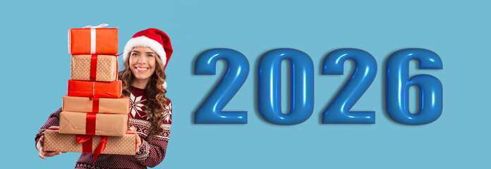 Obraz premium A woman is holding a stack of colorful gift boxes. The backdrop shows large blue numbers indicating the year 2026. This scene captures the excitement of a celebration.
