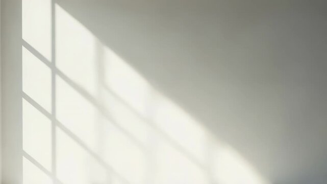 Bright sunlight casts strong geometric window frame shadows across a clean white floor and wall in a minimalist, empty interior serene, modern architectural composition