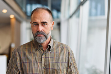 A man in a blue shirt is standing in office, businessman portrait