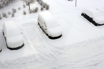 Snow-covered cars in winter storm at parking lot