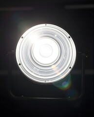 Round Studio Light Fixture Emitting Bright Illumination Against Dark Background