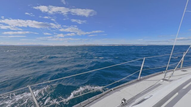 Valencia sailboat sailing on Mediterranean Sea with sun reflections