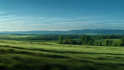 Obraz premium Green fields and distant hills under blue sky