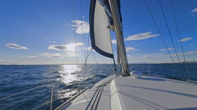 Valencia sailboat sailing on Mediterranean Sea with sun reflections