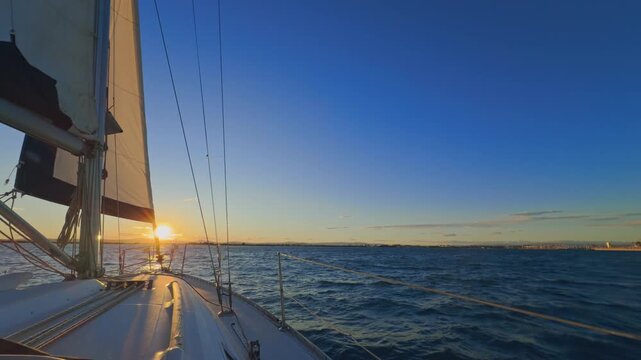 Valencia sailboat at sunset cruising on Mediterranean sea with golden light