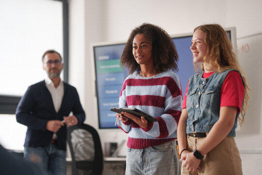 Two classmates presenting group project in front of class.