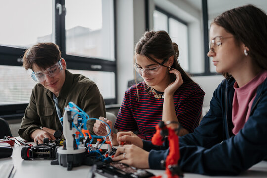 High school students working on robotics project as team.