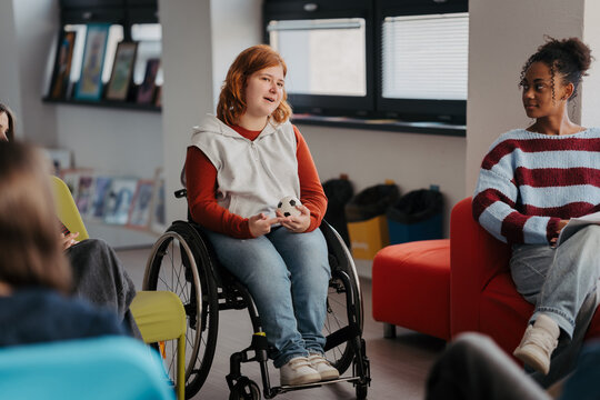 Teen students talking together in inclusive school setting.
