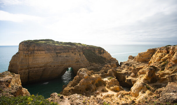 Panoramic, overhead view of the Algave coast featuring Farol de Alfanzina lighthouse