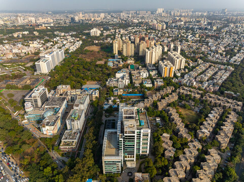 Aerial view of buildings and trees contrasting with the urban landscape, Sector 15B Delhi - Jaipur Expressway, Gurugram, Haryana, India.