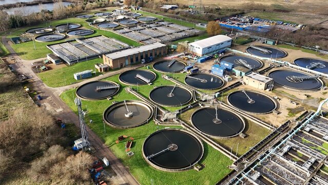 Aerial view of circular tanks shimmering under the winter sun, juxtaposed against the rigid structures, Hoddesdon, United Kingdom.