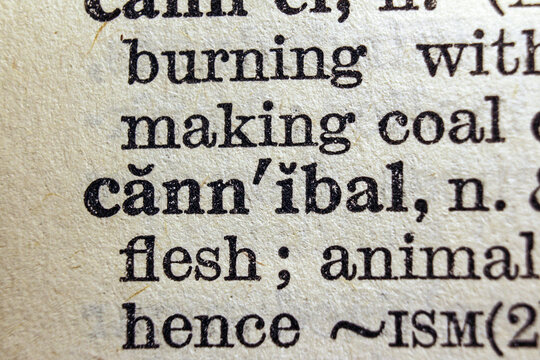 Word cannibal printed on dictionary page, macro close up