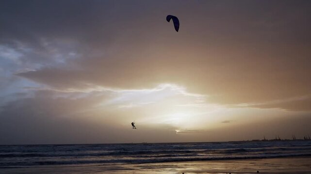Sporty lifestyle kitesurfing on ocean at sunset