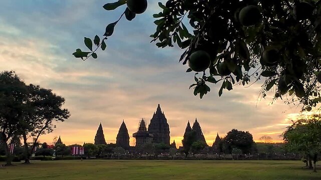 View of the ancient Prambanan Temple at sunset, a Hindu temple complex in Yogyakarta,Indonesia. The temple rises above the green foliage under a multicolored sky, on the southern slope of Mount Merapi