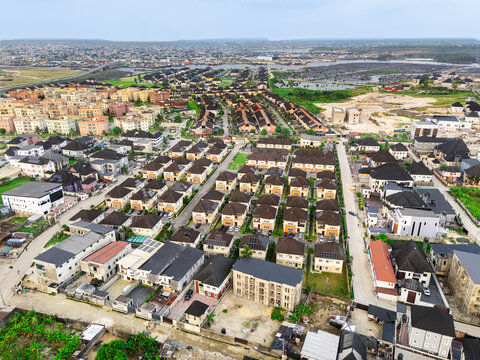 Aerial view of rooftops and roads create a geometric tapestry, with buildings casting long shadows in the Ede Okia Community, Port Harcourt, Rivers, Nigeria.