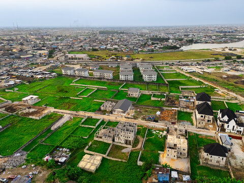 Aerial view of a community with vibrant green patches contrasting with buildings under construction and completed homes, Port Harcourt, Rivers, Nigeria.