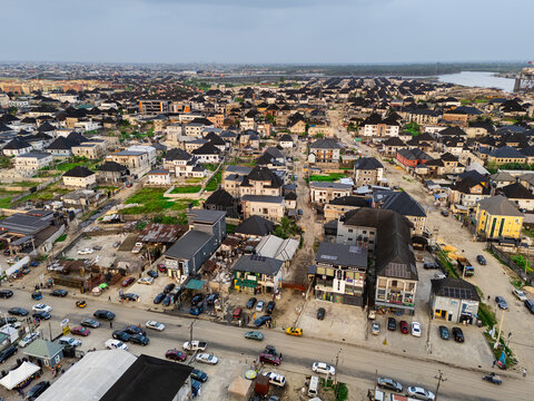 Aerial view of rooftops and roads interwoven with a tapestry of buildings and vehicles, creating a vibrant urban landscape along Ede Okia Community Road, Port Harcourt, Rivers, Nigeria.