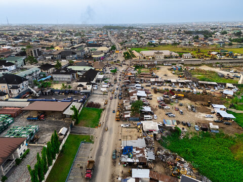 Aerial view of the bustling Ede Okia Community Road, a vibrant scene of commerce and transit amid the city's sprawling landscape, Port Harcourt, Rivers, Nigeria.