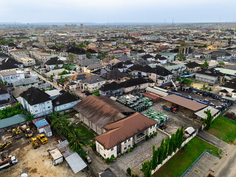 Aerial view of rooftops and industrial buildings interspersed with greenery under a soft, diffused light, Ede Okia Community Road, Port Harcourt, Rivers, Nigeria.